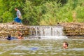 Many people swimming at the small weir irrigate