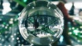Many people walk in Christmas and New Year decorated shopping mall. Distorted view through the glass ball Royalty Free Stock Photo