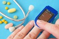 many pills, stethoscope, pulse oximeter for finger tip simultaneous monitoring of blood flow and transcutaneous oxygen on table Royalty Free Stock Photo