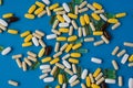 top view of many pills tablets gel and capsules of medicine pharmacy on blue surface