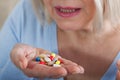 Many pills in woman hands. closeup on white background, macro selective focus.