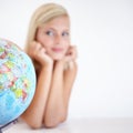 So many places to see...A young woman looking a globe of the earth wondering where to go next.