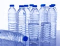 Many plastic water bottles and a glass of water on the table. Royalty Free Stock Photo