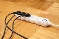 Many plugs plugged into electric power bar on floor Royalty Free Stock Photo