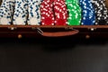 Many poker chips in a suitcase isolated on a black background. Poker Royalty Free Stock Photo