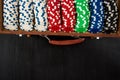 Many poker chips in a suitcase isolated on a black background. Poker Royalty Free Stock Photo