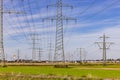 Many power poles and power lines in front of houses of a settlement in the background Royalty Free Stock Photo