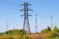 Many power poles, wires, communication towers, antennas against the background of spring nature and the blue sky