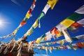 many prayer flags fluttering against a clear blue sky