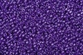 Many purple glass cane beads, background.