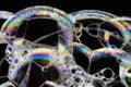 Many rainbow bubbles on a black background. Abstract detail