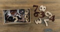 many random arabic numerals in a cardboard box on wooden table. Top view