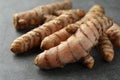 Many raw turmeric roots on grey table, closeup Royalty Free Stock Photo
