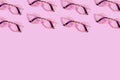 Many reading glasses on pink background pattern