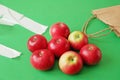 Many red apples on paper bag vs polyethylene bag on green background, green grocery concept, Royalty Free Stock Photo