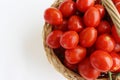 Many red cherry tomatoes with sepals in the basket isolated on the white background. Tomato pile. Ripe and fresh organic Royalty Free Stock Photo