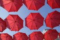 Many Red Umbrellas Against The Blue Sky. View From Below. Abstract Background With Red Umbrellas.