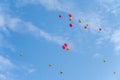 Many red and gold balloons fly under the blue sky and white clouds Royalty Free Stock Photo