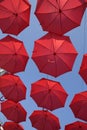 Many Red Umbrellas Against The Blue Sky. View From Below. Abstract Background With Red Umbrellas.