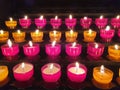 Many Red and yellow glowing prayer candles inside a catholic church on a candle rack Royalty Free Stock Photo