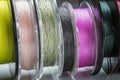 Many reels with fishing line and braided fishing line in different colors