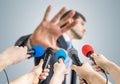 Many reporters are recording with microphones a politician who shows no comment gesture Royalty Free Stock Photo