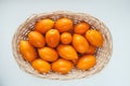 Many ripe juicy yellow tomatoes in a light straw basket