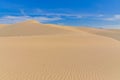 Many ripples wave lead to peak of sand dunes under sunny blue cloud sky in Nam Cuong, Phan Rang, Viet Nam.