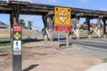 Many road signs at a low clearance overhead trestle bridge Royalty Free Stock Photo