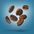 Many roasted coffee beans falling on light blue background Royalty Free Stock Photo