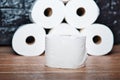 Many rolls of bathroom toilet paper on a wood and dark background Royalty Free Stock Photo