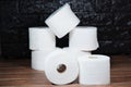 Many rolls of bathroom toilet paper on a wood and dark background Royalty Free Stock Photo