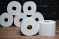 Many rolls of bathroom toilet paper on a wood and dark background Royalty Free Stock Photo