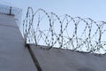 Many rows of barbedwire, high concrete fence, barbed wire fence on top, building for execution of punishments for criminals, Royalty Free Stock Photo