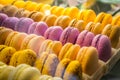 Many rows of different coloured french sweet macarons with different flavours