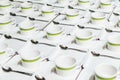 Many rows of white cup empty and trays with teaspoon beautifully placed on the table.