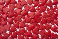 Many ruby red sugar hearts randomly scattered on white background Royalty Free Stock Photo