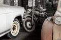 Many rusty abandoned forgotten antique oldtimer old car and motorcycles at junkyard factory storage warehouse indoors Royalty Free Stock Photo