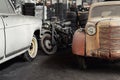 Many rusty abandoned forgotten antique oldtimer old car and motorcycles at junkyard factory storage warehouse indoors