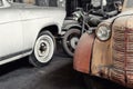 Many rusty abandoned forgotten antique oldtimer old car and motorcycles at junkyard factory storage warehouse indoors Royalty Free Stock Photo