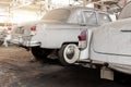 Many rusty abandoned forgotten antique oldtimer old car and motorcycles at junkyard factory storage warehouse indoors Royalty Free Stock Photo