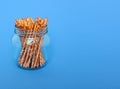Many salted sticks in glass jar over a blue background Royalty Free Stock Photo
