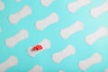 Many Sanitary pads on a blue background in the form of a diagonal pattern with a flower. Textured background all over the screen