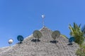 Many satellite antennas on a thatched roof against a blue sky on the island of Zanzibar, Tanzania, Africa Royalty Free Stock Photo