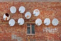 Many satellite dishes are attached to the wall of an old house. Royalty Free Stock Photo