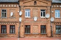 Many satellite dishes on the facade of an old red brick building Royalty Free Stock Photo