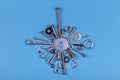 Many screws nuts and metal washers isolated on blue