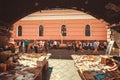 Many second hand books for sale and customers walking around weekend antique market of historical city