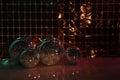 Many shiny disco balls on floor near foil party curtain. Space for text Royalty Free Stock Photo