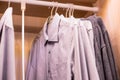 Many shirts hanging on a rack.Row of men`s suits hanging in closet. concept of buy and sell, business man.Man`s closet